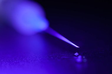 Damlalı şırınga ucu, koyu arkaplan