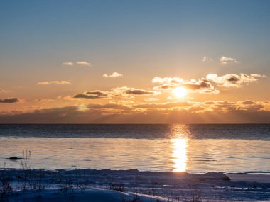 Gün batımında soğuk kış kıyısı. Güneş battı.