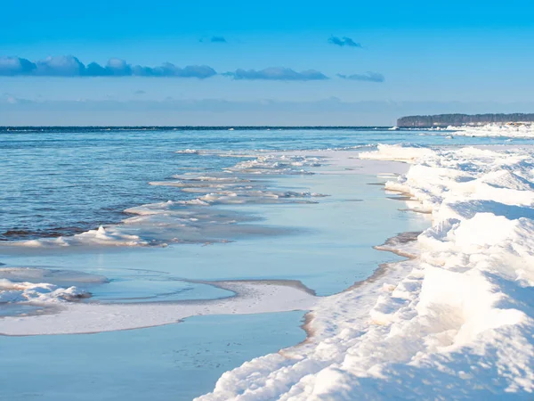 寒い冬の海の海岸 海の氷の破片 小さな雲と青い空 — ストック写真
