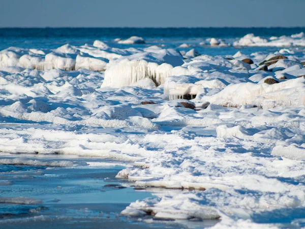 冬には 石は海の岸に氷です 氷の塊から吊るされたつらら — ストック写真