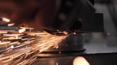 Metal parçaları incelerken kıvılcımlar her yöne doğru uçar. Fabrikada metal işleme. El işi.