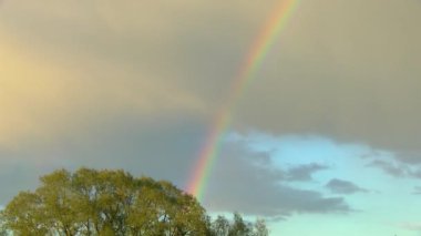 Gün batımında yağmur bulutları üzerinde gökkuşağı
