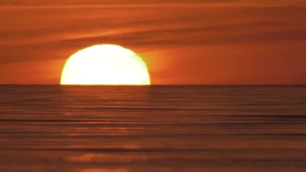 水平線の上の歪んだ暖かい空気の中で大きな赤い熱い太陽 太陽は地平線の下で海に沈む 海の美しい夕日 — ストック動画