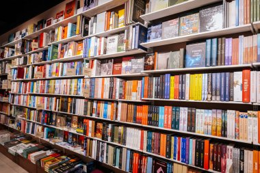 Renkli ve çeşitli türlerde kitaplarla dolu canlı bir kitapçı rafı okuyucular ve kitap severler için cennet sunuyor. 06.10. 2025 Valmiera, Letonya