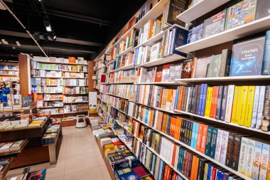 Renkli ve çeşitli türlerde kitaplarla dolu canlı bir kitapçı rafı okuyucular ve kitap severler için cennet sunuyor. 06.10. 2025 Valmiera, Letonya