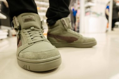 Zeytin yeşili Puma yüksek topuklu ayakkabılar, kahverengi detaylar, spor stili ve sokak kıyafetlerinin birleşimi, gündelik ve şehir modası için ideal. 06.10. 2025 Valmiera, Letonya