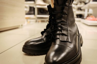 Dekoratif fırfırlı detaylarla süslü siyah deri çizmeler ve tıknaz tabanlar. Cesur ve şık bir görünüm için kenar moda ve kadınsı bir yetenekle harmanlanmış..