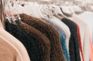 Çeşitli renk ve dokulardaki süveterler perakende bir ortamda düzgünce sergilenerek, şık kış kıyafetleri arayanlar için davetkar bir atmosfer yaratıyor.