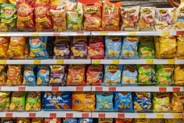 Valmier, Letonya - 24 Kasım 2025: Lay 's ve Adazu' dan canlı patates cipsi paketleri süpermarket raflarında düzenlendi ve aperatifleri tatları keşfetmeye davet etti.