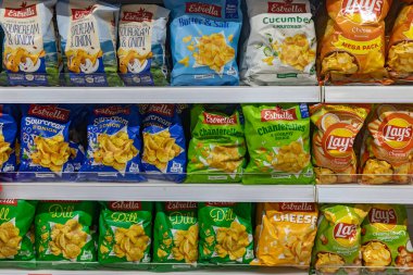 Valmier, Letonya - 24 Kasım 2025: Estrella ve Lay 'den canlı patates cipsi paketleri süpermarket raflarında, ekşi krema, dereotu ve peynir gibi tatları vurguluyor