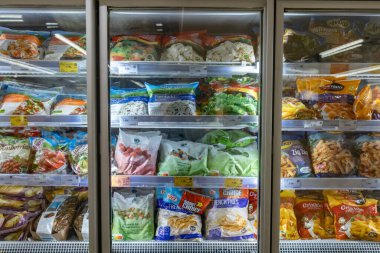 Valmier, Letonya - 24 Kasım 2025: Süpermarket dondurulmuş gıda bölümü çeşitli sebze, meyve ve atıştırmalık paketleri, kolaylık ve sağlıklı seçenekleri vurguluyor