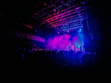 Valmier, Letonya - 06 Aralık 2025: Sahnede renkli ışıklandırmalı müzisyenlerin yer aldığı konser sahnesi seyirciler için enerjik bir ortam yaratıyor