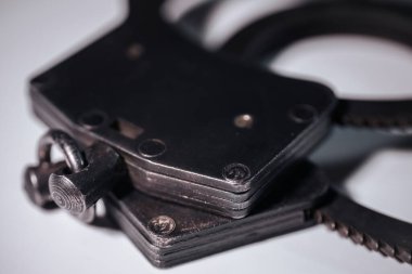 Klasik kelepçelerin ayrıntılı yakın çekimi, zanaat ve mekanik özelliklerin altını çizmek, yumuşak bir arkaplan karşılamak, güvenlik ve yasa uygulama temaları çağrıştırmak