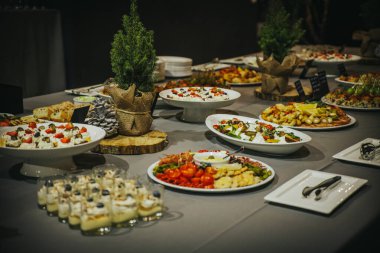 Açık büfe, taze salatalar, lezzetli mezeler ve lezzetli tatlılar da dahil olmak üzere bir dizi renkli yemek sergiliyor. Misafirler için davetkar bir ortam yaratıyor.