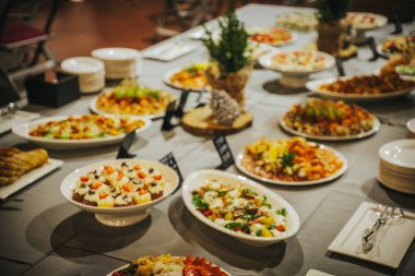 Açık büfe, içinde salatalar, pastalar ve meyveler de dahil olmak üzere canlı yemeklerden oluşan bir dizi sunar. Kutlama atmosferi için güzel bir şekilde düzenlenmiştir.