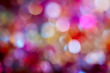 Pembe, mor, mavi ve altın tonlarında renkli bokeh ışıkları olan soyut bir arka plan çeşitli tasarım için yumuşak ve rüya gibi bir görsel efekt yaratır.