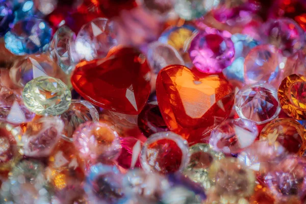 Kırmızı kalp şeklindeki kristaller ve çeşitli renkli mücevherler de dahil olmak üzere çeşitli pırıl pırıl parlayan taşlar tasarım amaçlı fotokopi alanı ile canlı bir ekrana yerleştirildi.