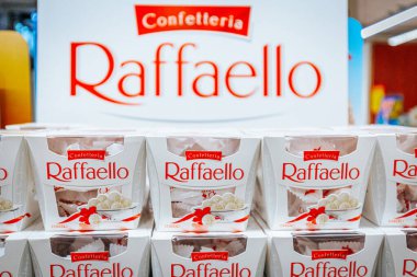 Raffaello şekerleme kutuları bir perakende ayarı düzenlenmiştir, ürün gösteriminin üzerinde marka adı kırmızı gösterilen büyük bir tabela