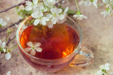 Bahar çiçeği ile cam fincan siyah çay üzerinde eski w şubeleri