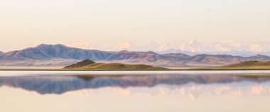 Kazakistan 'daki Tuzkol Gölü ve yazın gündoğumunda Khan Tengri Tepesi manzarası