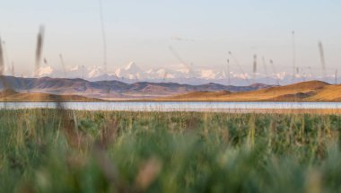 Kazakistan 'daki Tuzkol Gölü ve yazın gündoğumunda Khan Tengri Tepesi manzarası