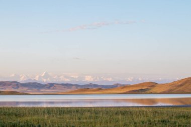 Kazakistan 'daki Tuzkol Gölü ve yazın gündoğumunda Khan Tengri Tepesi manzarası