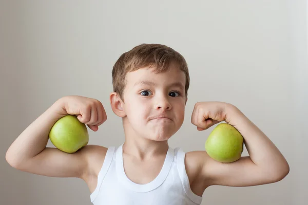 Menino com maçãs mostrar bíceps — Fotografia de Stock