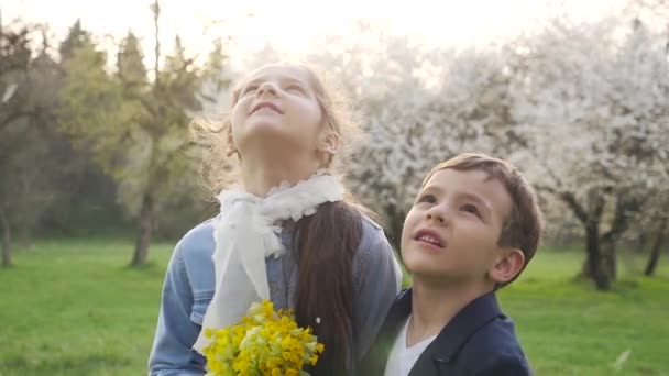 Niños felices, árbol de pétalos que cae — Vídeo de stock