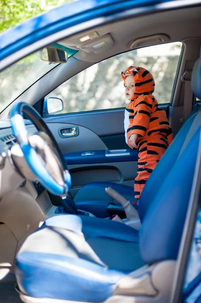 Petit garçon en costume de tigre est dans la voiture — Photo
