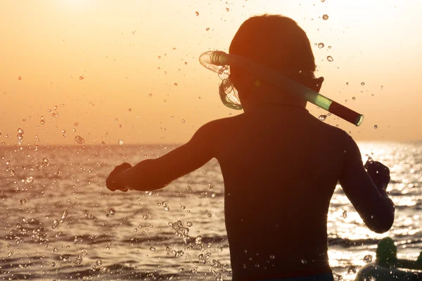 Bambino con maschera e boccaglio sullo sfondo del tramonto del mare — Foto Stock