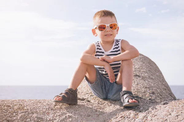 Jongen in zonnebril op de achtergrond van de zee — Stockfoto