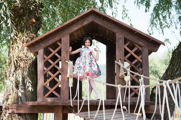 나무 집에서에 서 있는 드레스에 아름 다운 소녀 — 스톡 사진