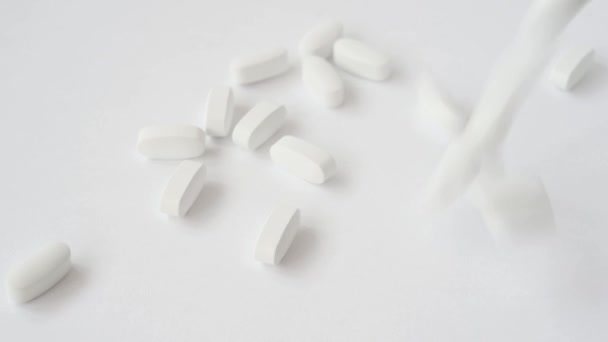 Witte pillen tabletten vallen neer op helder zuiver oppervlak — Stockvideo
