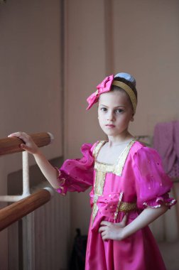 beautiful little russian girl in traditional costume barre exercise in ballet dance school clipart