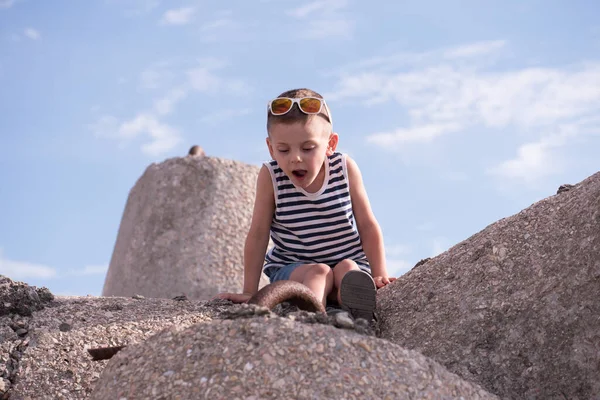 Bambino in giubbotto si siede sullo sfondo del cielo — Foto Stock