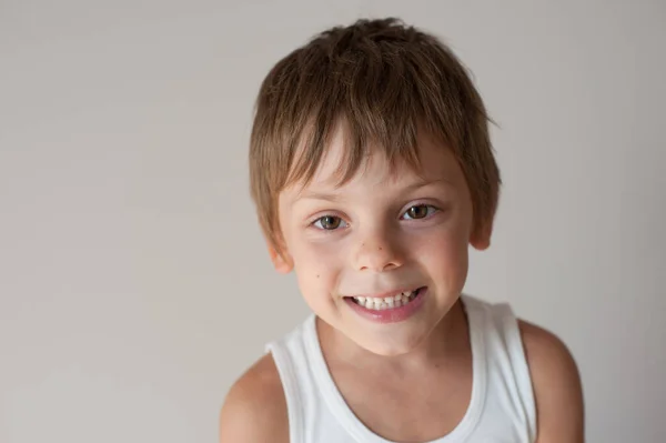 Rozkošný šťastný usmívající se malý kluk v tílku na pozadí s kopírovacím prostorem — Stock fotografie