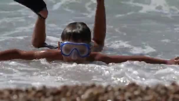 Активний маленький хлопчик, який плаває і занурюється в маску і плавці на літньому водному морському пляжі під час подорожей відпочинок дозвілля — стокове відео