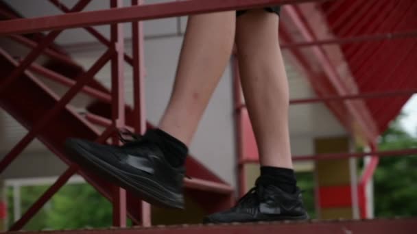 Adolescente activo en zapatillas de deporte mejorar sus habilidades de fútbol haciendo mantiene ups keepie uppie en la calle escalera urbana en cámara lenta — Vídeos de Stock