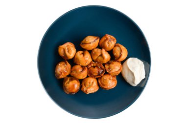 Beyaz izole edilmiş fotokopi arka planında mavi tabakta beyaz ekşi krema soslu geleneksel Çin köftesi.