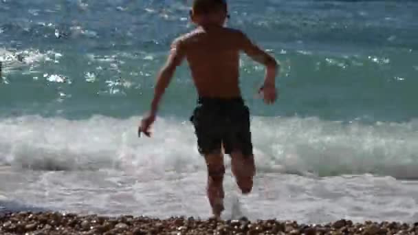 Aktiv frisk liten unge i dykning mask som rinner in i vatten med vågor och stänk under sommarlovet — Stockvideo