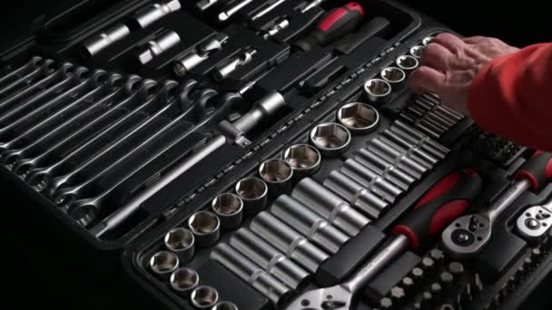 Closeup hands of man in red shirt choosing and taking tools from black toolkit connecting and rotating head and chrome spanner ratchet wrench — Stock Video