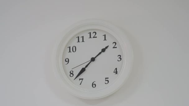 Концепция времени белых круглых часов на ярко чистой стене в офисе — стоковое видео