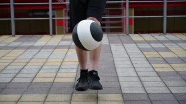 Spor ayakkabısı giyen aktif bir genç çocuk futbol yeteneklerini geliştiriyor. Sokak sporları sahasında ayak uydurmasını sağlıyor.