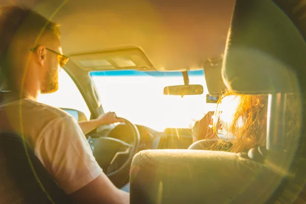 Man and woman in auto travel on a sunny day