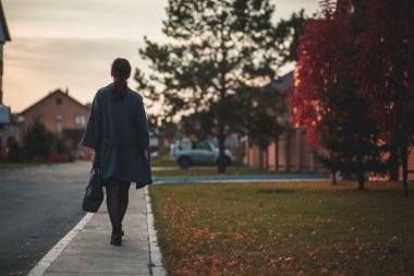genç kadın, sokakta yürürken gri paltolu sonbahar. Arkadan Görünüm 