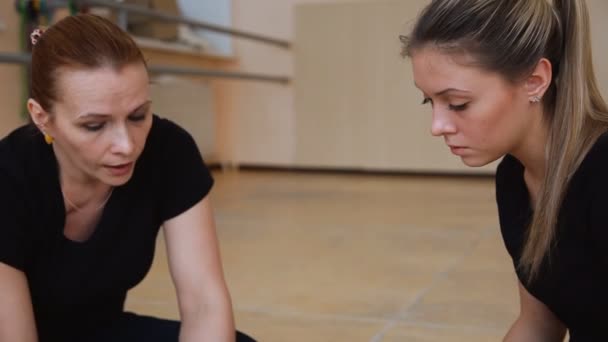 Duas mulheres, dançarinas vestidas de preto, inventam uma nova dança. no chão . — Vídeo de Stock