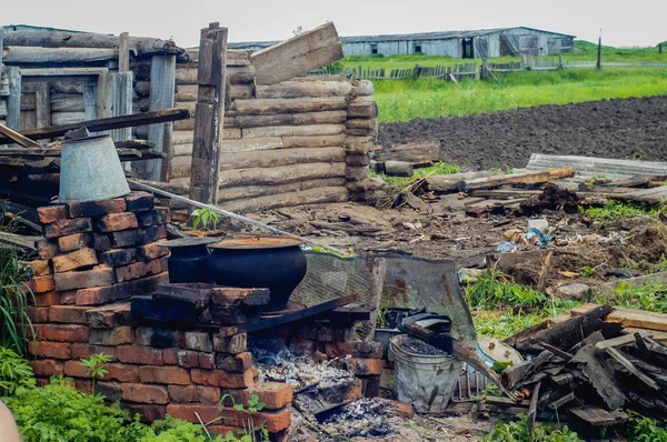 Abandonado arruinado casa vieja, choza. En el medio hay una estufa. El techo caído . — Foto de Stock