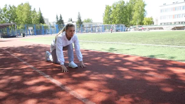 Спортивная девушка на беговой дорожке готова управлять большим стадионом — стоковое видео