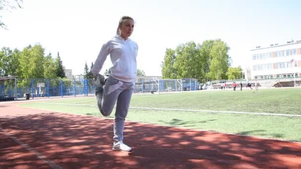 Young beauty girl do exercises at the stadium — Stock Video