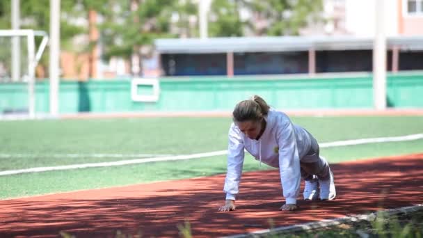 Gadis cantik muda melakukan latihan di stadion — Stok Video